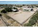 Stunning aerial view of the property, showcasing the horse arena, charming single-story home and surrounding landscape at 18637 E Flintlock Dr, Queen Creek, AZ 85142