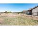 Fenced backyard with a view of the home, offering security and a clear landscape with natural vegetation at 18637 E Flintlock Dr, Queen Creek, AZ 85142