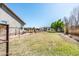 Spacious backyard featuring a fenced perimeter, lush grass, and a horse shelter in the distance at 18637 E Flintlock Dr, Queen Creek, AZ 85142