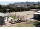 Aerial view of a backyard with a horse arena, covered patio, and surrounding desert landscape at 18637 E Flintlock Dr, Queen Creek, AZ 85142
