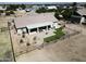 Aerial view of a backyard featuring a covered patio, well-maintained lawn, and desert landscape at 18637 E Flintlock Dr, Queen Creek, AZ 85142