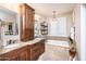 Bathroom featuring double sinks with granite countertops and a soaking tub underneath a pendant light at 18637 E Flintlock Dr, Queen Creek, AZ 85142