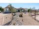 Single-story home featuring desert landscaping, a decorative rock-lined drainage path, and a fenced perimeter at 18637 E Flintlock Dr, Queen Creek, AZ 85142