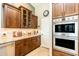 Kitchen featuring built-in stainless oven, dark wood cabinets, and light granite countertops at 18637 E Flintlock Dr, Queen Creek, AZ 85142