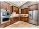 Well-equipped kitchen with built-in oven, granite countertops, and ample dark wood cabinet space at 18637 E Flintlock Dr, Queen Creek, AZ 85142