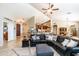 Spacious living room with a modern sectional, opening to the kitchen and dining area at 18637 E Flintlock Dr, Queen Creek, AZ 85142
