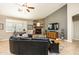 Cozy living room with a stone fireplace, dark leather sectional, and natural lighting at 18637 E Flintlock Dr, Queen Creek, AZ 85142