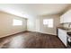 Open floor plan of kitchen and bonus room with stainless steel appliances, light walls and hard wood flooring at 2027 W Monte Vista Rd, Phoenix, AZ 85009