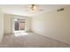 Bright bedroom with neutral carpet, ceiling fan, and sliding glass door to patio at 2104 W Yukon Dr, Phoenix, AZ 85027