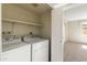 Bright laundry area with shelving and modern appliances, adjacent to a bedroom at 2104 W Yukon Dr, Phoenix, AZ 85027