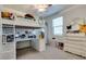 Bright bedroom featuring lofted bed with built in desk, white dresser and large window, offering stylish functionality at 21407 W Hubbell St, Buckeye, AZ 85396