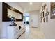 Hallway with neutral tile flooring, white dresser, mirror and decor at 21407 W Hubbell St, Buckeye, AZ 85396