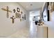 Light-filled hallway featuring tiled floors, decorative wall art, a mirror, and views into the living space at 21407 W Hubbell St, Buckeye, AZ 85396