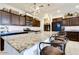 Gorgeous kitchen featuring a large island with bar seating, granite countertops, and dark wood cabinets at 21407 W Hubbell St, Buckeye, AZ 85396