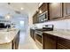 Modern kitchen features stainless steel appliances, dark wood cabinets, and granite countertops at 21407 W Hubbell St, Buckeye, AZ 85396