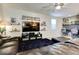 Spacious living area with a leather sofa, decorative shelves, TV setup, and adjacent home office space at 21407 W Hubbell St, Buckeye, AZ 85396