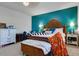 Warm main bedroom with a wooden headboard, turquoise accent wall, and elegant bedside tables offering style and comfort at 21407 W Hubbell St, Buckeye, AZ 85396