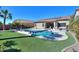 An expansive backyard with an artificial lawn, a pool, and a hot tub offers a relaxing outdoor space at 21857 N Gibson Dr, Maricopa, AZ 85139