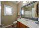 Bathroom showcasing a toilet, vanity, mirror, and plantation shutters on the window at 21857 N Gibson Dr, Maricopa, AZ 85139