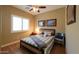 Bedroom with a ceiling fan, a bed with a striped comforter, and wood-look flooring at 21857 N Gibson Dr, Maricopa, AZ 85139