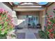 Inviting front porch with seating area and beautiful flowering plants, creating a warm welcome at 21857 N Gibson Dr, Maricopa, AZ 85139