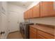 Well-equipped laundry room featuring modern washer and dryer, convenient counter space, and ample cabinet storage at 21857 N Gibson Dr, Maricopa, AZ 85139