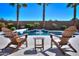 Inviting backyard pool area with waterfall feature and comfortable lounge chairs, perfect for relaxing and entertaining outdoors at 21857 N Gibson Dr, Maricopa, AZ 85139