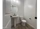 A powder room featuring a pedestal sink with a round mirror and toilet at 22961 E Twin Acres Dr, Queen Creek, AZ 85142