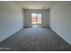 Spacious bedroom featuring plush carpet and large window offering ample natural light at 22961 E Twin Acres Dr, Queen Creek, AZ 85142