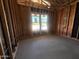 Unfinished bedroom showing framed walls with visible studs, insulated wiring, and bright natural light at 22961 E Twin Acres Dr, Queen Creek, AZ 85142