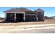 Charming home under construction with a neutral color scheme and spacious garage, set against a clear blue sky at 22961 E Twin Acres Dr, Queen Creek, AZ 85142