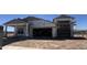 Unfinished home with a two-car garage and a covered porch framed by columns under a clear, sunny sky at 22961 E Twin Acres Dr, Queen Creek, AZ 85142