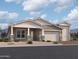 New construction home featuring a two-car garage, a welcoming front porch, and professionally landscaped front yard at 22961 E Twin Acres Dr, Queen Creek, AZ 85142