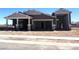 New home under construction featuring a spacious three car garage with open doorways and a desert-style landscape at 22961 E Twin Acres Dr, Queen Creek, AZ 85142