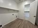 A bright laundry room features a shelf above hookups and a door to a walk-in closet at 22961 E Twin Acres Dr, Queen Creek, AZ 85142
