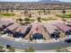 Aerial view of a house in a neighborhood next to a golf course, with mountains in the distance at 2643 E San Ricardo Trl, Casa Grande, AZ 85194