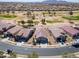 Aerial view of a house in a neighborhood next to a golf course, with mountains in the distance at 2643 E San Ricardo Trl, Casa Grande, AZ 85194