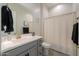 Bathroom with white countertop, gray vanity, sink, and toilet, plus a shower with a white curtain at 2643 E San Ricardo Trl, Casa Grande, AZ 85194