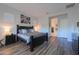Comfortable bedroom featuring wood-look floors, neutral colors, and an ensuite entrance to bathroom at 2643 E San Ricardo Trl, Casa Grande, AZ 85194
