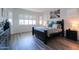 Bright bedroom with plantation shutters, dark wood furniture, and luxury vinyl plank flooring at 2643 E San Ricardo Trl, Casa Grande, AZ 85194