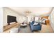 Bright, open-concept living room with modern furnishings and a large television on a wooden shelf at 2725 W Silver Creek Ln, San Tan Valley, AZ 85144