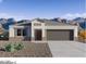 New construction home with a gray color palette, low-maintenance desert landscaping, and a mountain backdrop at 28200 N Nealite Dr, San Tan Valley, AZ 85143