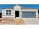 Charming single-story home featuring a gray roof, blue garage door, and a clean, modern facade at 28200 N Nealite Dr, San Tan Valley, AZ 85143