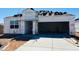 New construction home featuring open garage, paved driveway, and roof tiles ready for installation at 28200 N Nealite Dr, San Tan Valley, AZ 85143