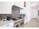 Modern kitchen featuring stainless steel range with red knobs and dark decorative tile backsplash at 28282 N 158Th St, Scottsdale, AZ 85262