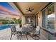 Inviting covered back patio featuring outdoor seating, ceiling fan and a view of the pool at 4088 E Comstock Dr, Gilbert, AZ 85296
