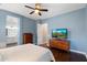 Bright bedroom featuring hardwood floors, ceiling fan, and an adjacent bathroom at 4088 E Comstock Dr, Gilbert, AZ 85296