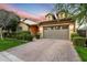 Inviting home showcasing a brick driveway, lush bushes, and an attached two-car garage with a warm, sunset sky at 4088 E Comstock Dr, Gilbert, AZ 85296