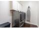 Bright laundry room with a gray washer and dryer, white cabinets, wood-look floors, and an ironing board at 4088 E Comstock Dr, Gilbert, AZ 85296