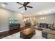 Open living area with hardwood floors, large TV, ceiling fan and adjoining kitchen at 4088 E Comstock Dr, Gilbert, AZ 85296